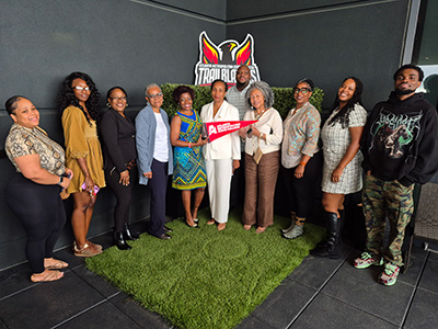 President Thompson-Sellers standing with alumni at rooftop networking event